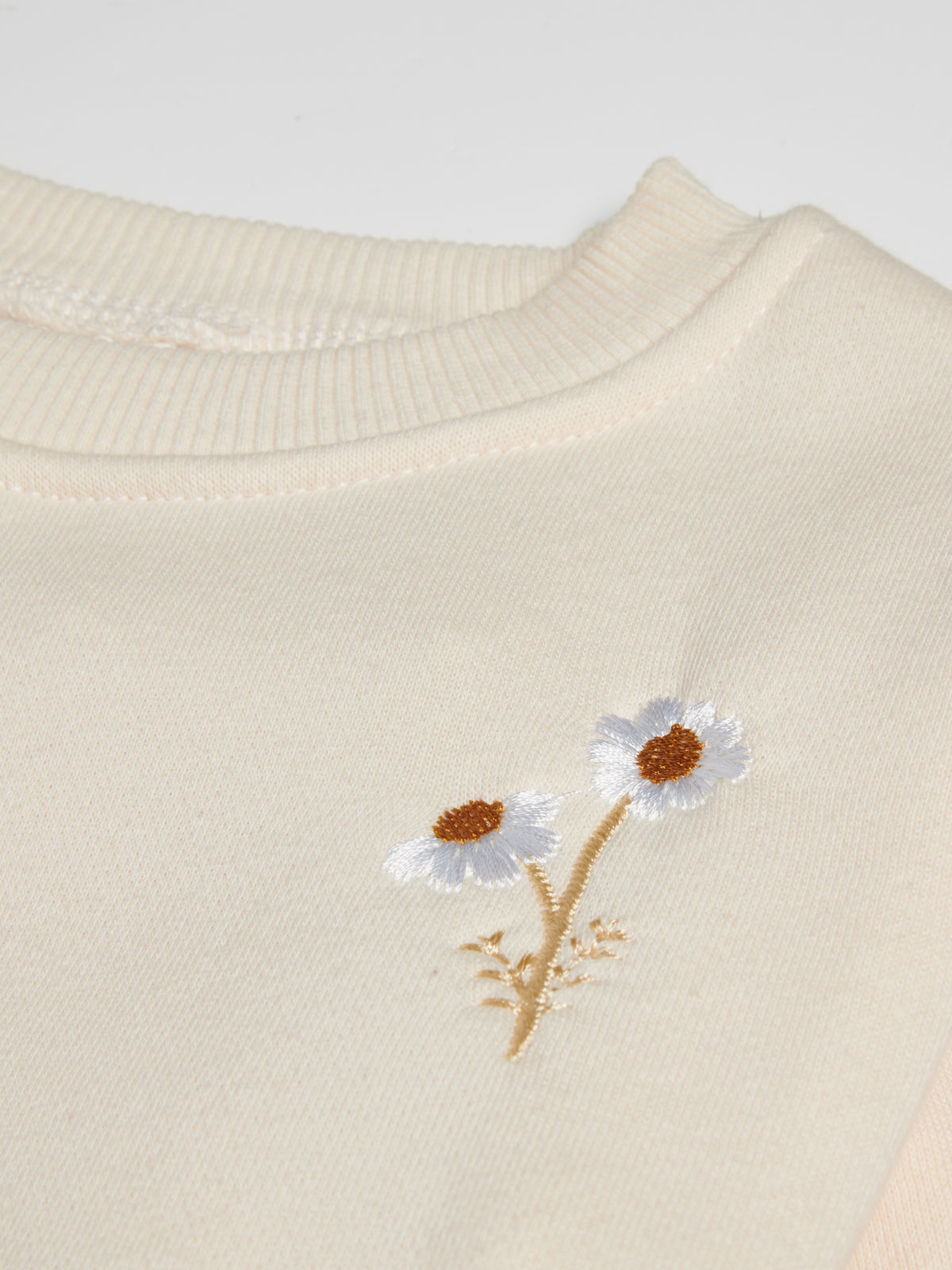 Embroidered Floral Set close-up of daisy embroidery on cream cotton baby sweatshirt
