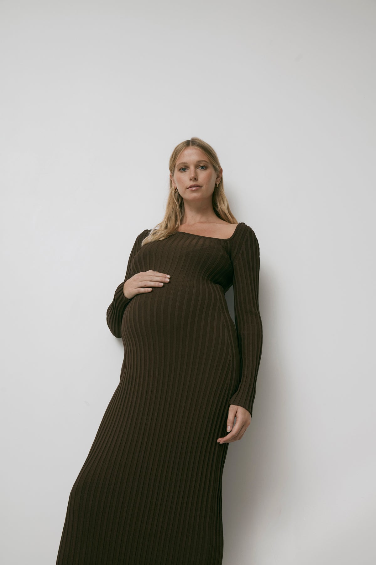 The Allegra brown knitted maternity dress, model cradling bump